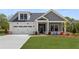 Charming home with a two-car garage, gray siding and a beautifully landscaped yard at 5210 Ginger Rose Ct, Cumming, GA 30028