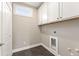 Neat laundry room with gray tile flooring and storage at 5210 Ginger Rose Ct, Cumming, GA 30028