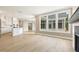 Open concept living area with hardwood floors and bright light flowing in from large windows at 5210 Ginger Rose Ct, Cumming, GA 30028