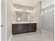 Elegant bathroom with double sink vanity, large mirror, and walk-in shower with bench at 5210 Ginger Rose Ct, Cumming, GA 30028