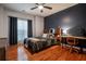 Bright bedroom with hardwood floors, a comfortable bed, and a built-in workspace at 7655 Abbey Glen Dr, Cumming, GA 30028