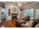 Spacious living room with hardwood floors, stone fireplace, and built-in shelving at 7655 Abbey Glen Dr, Cumming, GA 30028