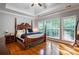 Main bedroom with hardwood floors, large windows, and a ceiling fan at 7655 Abbey Glen Dr, Cumming, GA 30028