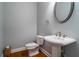 Convenient powder room with pedestal sink and hardwood floor at 7655 Abbey Glen Dr, Cumming, GA 30028