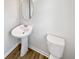 Cozy powder room with pedestal sink and wood-look flooring at 55 Cherohala Ct, Covington, GA 30016
