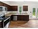 Well-equipped kitchen with stainless steel appliances, dark cabinets, and granite countertops at 55 Cherohala Ct, Covington, GA 30016