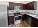 Modern kitchen with stainless steel appliances, dark cabinets, and granite countertops at 55 Cherohala Ct, Covington, GA 30016