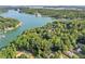 Aerial view showcases the lush, wooded neighborhood and waterfront area, highlighting the natural beauty of the surroundings at 5775 Lakeshore Dr, Buford, GA 30518