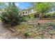 Backyard view of home, with a concrete retaining wall, lush foliage and view of second story porch at 5775 Lakeshore Dr, Buford, GA 30518