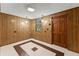 Cozy basement with paneled walls, neutral flooring, and an exterior door at 5775 Lakeshore Dr, Buford, GA 30518