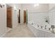 Bathroom showcasing a soaking tub and white vanity with wood doors at 5775 Lakeshore Dr, Buford, GA 30518