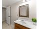 Bright bathroom features a framed mirror, decorative plant, and traditional cabinet at 5775 Lakeshore Dr, Buford, GA 30518