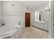 Elegant bathroom featuring a large soaking tub, white cabinets, and ceramic tile floor at 5775 Lakeshore Dr, Buford, GA 30518