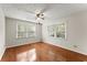 Sunlit bedroom features hardwood floors, a ceiling fan, and large windows for natural light at 5775 Lakeshore Dr, Buford, GA 30518