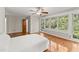 Spacious bedroom with hardwood floors, ceiling fan, and view of the yard at 5775 Lakeshore Dr, Buford, GA 30518