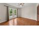 Hardwood floored bedroom with double doors to a deck, ceiling fan and a closet at 5775 Lakeshore Dr, Buford, GA 30518