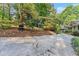 Mature trees frame the side view of this home with landscaped grounds and a long driveway at 5775 Lakeshore Dr, Buford, GA 30518