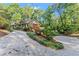 Traditional home nestled among mature trees with a brick facade and an expansive driveway at 5775 Lakeshore Dr, Buford, GA 30518