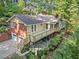 Back exterior view featuring a large deck, garage, and steps to the backyard at 5775 Lakeshore Dr, Buford, GA 30518
