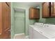 Practical laundry room with washer, dryer, and overhead cabinets for efficient home management at 5775 Lakeshore Dr, Buford, GA 30518