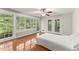 A large sunny main bedroom offers hardwood floors, a ceiling fan and access to a deck at 5775 Lakeshore Dr, Buford, GA 30518