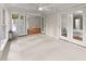 Bright sunroom featuring neutral carpeting, white trim, and double French doors at 5775 Lakeshore Dr, Buford, GA 30518