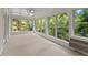 Relaxing sunroom enveloped by expansive windows, offering serene views of the lush, green outdoors at 5775 Lakeshore Dr, Buford, GA 30518