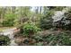Landscaped front yard with a variety of plants and trees along a brick path at 5775 Lakeshore Dr, Buford, GA 30518