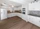 Bright kitchen featuring white cabinetry, stainless steel appliances, and hardwood flooring at 7131 Forest Ln, Union City, GA 30291