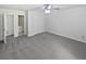 Bright main bedroom featuring plush gray carpeting and a ceiling fan, with convenient ensuite bathroom and closets at 7131 Forest Ln, Union City, GA 30291