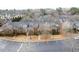 Aerial view of a townhome community with mature trees, ample parking, and lush landscaping at 905 Freedom Ln, Roswell, GA 30075