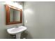 This bathroom features a pedestal sink with decorative mirror and vanity lighting at 905 Freedom Ln, Roswell, GA 30075