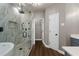 Modern bathroom with glass-enclosed shower, tub and neutral tile and flooring at 905 Freedom Ln, Roswell, GA 30075