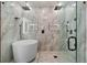 Modern bathroom with a glass shower enclosure, tub, and gorgeous white and gold tile at 905 Freedom Ln, Roswell, GA 30075