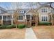 Inviting townhome exterior with a front porch, set amongst mature trees at 905 Freedom Ln, Roswell, GA 30075