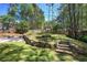 Backyard with stone retaining walls, a fire pit area, a sport court, and mature trees for privacy at 2921 Wickford Nw Dr, Kennesaw, GA 30152