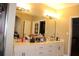 Bathroom featuring a large mirror, cabinet style vanity with double sinks and neutral tile floors at 2100 Indian Shoals Dr, Loganville, GA 30052