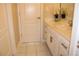 Neutral bathroom featuring a door, vanity, mirror with floral arrangement, and neutral tile floors at 2100 Indian Shoals Dr, Loganville, GA 30052
