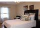 Inviting bedroom featuring a plush bed with decorative pillows, soft natural light, and stylish wall decor at 2100 Indian Shoals Dr, Loganville, GA 30052