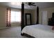 Bedroom features a four-poster bed, neutral carpeting and large window with decorative curtains at 2100 Indian Shoals Dr, Loganville, GA 30052