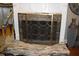 Fireplace detail featuring stone surround and decorative screen, with vase and table to the side at 2100 Indian Shoals Dr, Loganville, GA 30052