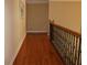 Upstairs hallway with hardwood floors and decorative railing at 2100 Indian Shoals Dr, Loganville, GA 30052
