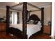 Spacious main bedroom with dark wood floors, a four post bed and a private patio at 2100 Indian Shoals Dr, Loganville, GA 30052