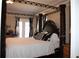 Spacious main bedroom with dark wood floors, a four post bed and a private patio at 2100 Indian Shoals Dr, Loganville, GA 30052