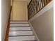 Staircase with white risers and wooden banister leading to upper level at 2100 Indian Shoals Dr, Loganville, GA 30052