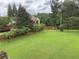 Spacious backyard with a well-maintained lawn, bordered by a wooden fence and mature trees at 4850 Guilford Forest Sw Dr, Atlanta, GA 30331