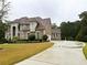 Traditional brick home with well-manicured lawn, mature trees, and a long driveway leading to the garage at 4850 Guilford Forest Sw Dr, Atlanta, GA 30331