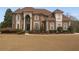 Elegant brick home featuring a manicured front lawn and stately architectural details at 4850 Guilford Forest Sw Dr, Atlanta, GA 30331