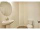 Cozy powder room featuring a pedestal sink, round mirror and toilet at 3201 Camden Ct, Atlanta, GA 30349