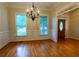 A naturally lit formal dining room featuring hardwood floors, wainscoting, and a decorative chandelier at 403 Pebblebrooke Ln, Canton, GA 30115
